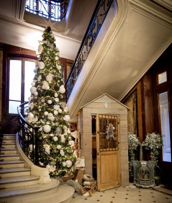 Sapin de Noël entreprise blanc et argent installé dans le hall d'un hôtel particulier