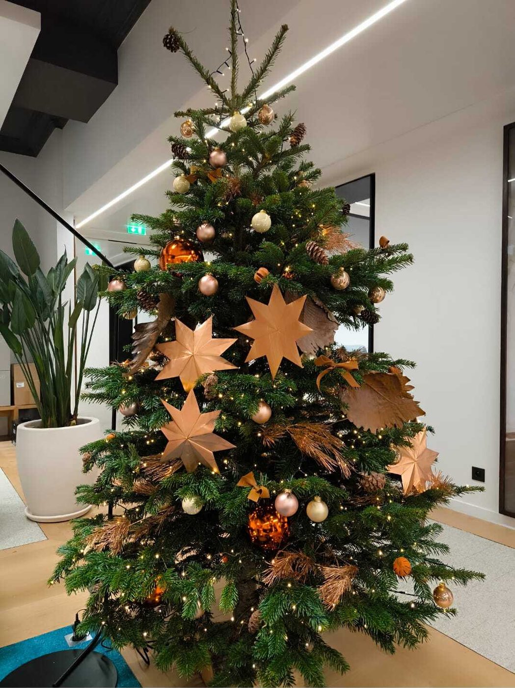 Sapin de Noël entreprise décoré d'étoiles en papier cuivre, style scandinave