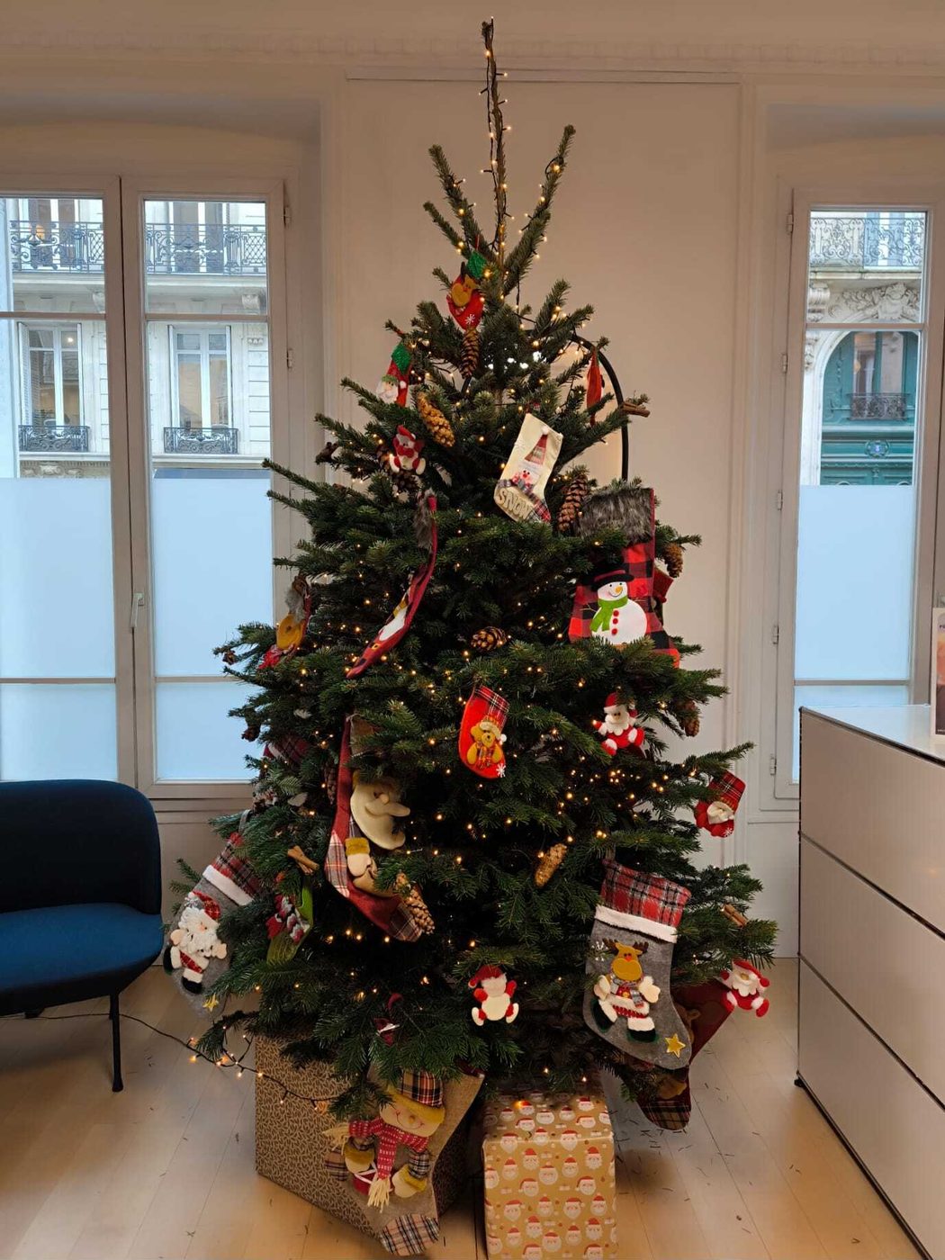Sapin de Noël traditionnel décoré de chaussettes dans des bureaux haussmanniens