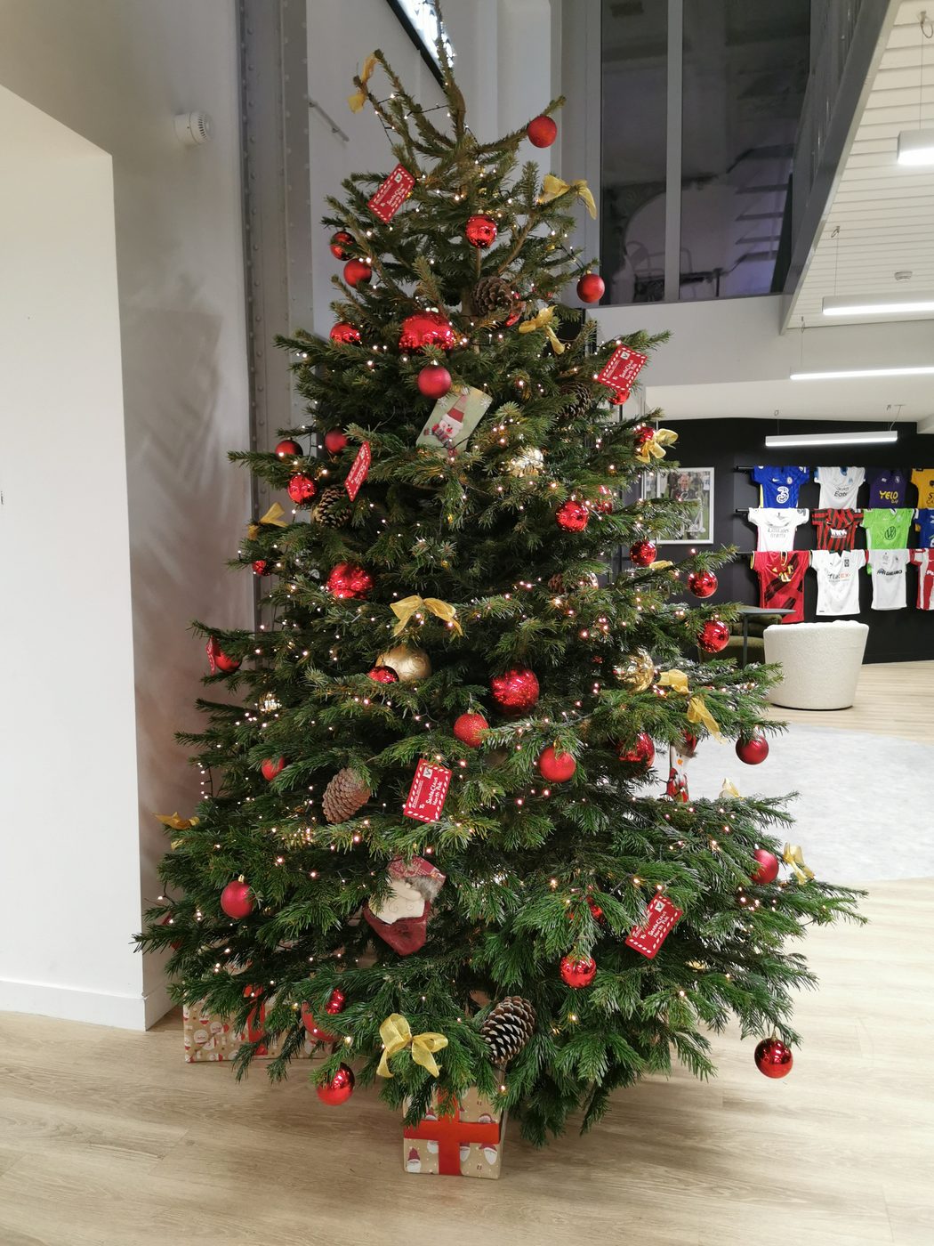 Grand sapin de Noël traditionnel rouge et or dans le hall d'accueil d'une entreprise